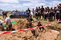 Men jumping in muddy water at Ultimate Mudness, athletic competition in Bucharest