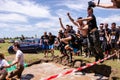 Men jumping in muddy water at Ultimate Mudness, athletic competition in Bucharest