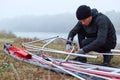 Men during kayaking, concentrated guy near canoe frame, going to padding, male in black sportswear on river bank in early foggy