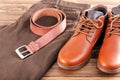 Men leather shoes, trousers and belt on a wooden table. Royalty Free Stock Photo