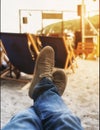 Men legs in sneakers on background of deckchairs on beach Royalty Free Stock Photo