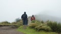 Men looking backwards walking towards the summit of the Rucu Pichincha volcano on a cloudy day, near the city of Quito