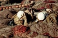 Men lying on fishing nets and discuss