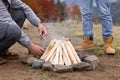 Men making bonfire outdoors, closeup. Camping season