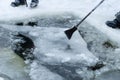 Men making ice-hole, cleaning it from ice pieces using crowbar