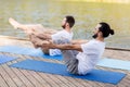 Men making yoga in half-boat pose outdoors