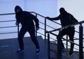 Men in masks with knife on stairs. Dangerous criminals