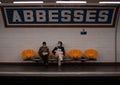 Men in masks sitting on the chairs and waiting for the metro in Paris, France