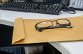 Men modern eyeglasses on brown confidential envelope on office desk Royalty Free Stock Photo