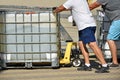 Men are moving a large water container Royalty Free Stock Photo