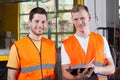 Men in orange protective vest working at factory