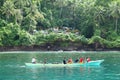 Men paddling by cemetery on tropical island Lembeh