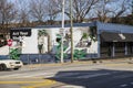 men painting a wall mural and cars driving on the street with bare winter trees and a gorgeous blue sky in Atlanta Georgia