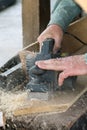 Men planing a plank of wood with a electric plane Royalty Free Stock Photo