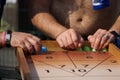 Men playing board game shuffleboard. No face. Selective focus Royalty Free Stock Photo