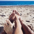 Men playing footsie on the beach