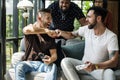 Men playing games together on couch Royalty Free Stock Photo