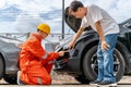 A man pointing out the scratches on his car from the car accident to the car insurance mechanic