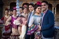 Men posing with women with traditional dresses