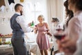 A man pouring guests wine on a indoor family birthday party. Royalty Free Stock Photo