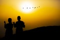 Men praying at sunrise. Birds and the Sun. Royalty Free Stock Photo