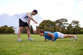 Men, push up and personal trainer on grass for workout with clipboard for test, progress or development. Person, coach Royalty Free Stock Photo