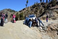 Men pushing a stranded tourist vehicle