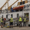 Men put into place a metal gangway on an arriving ferry in St Marys, Scilly Isles, UK Royalty Free Stock Photo