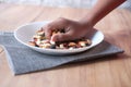 men reaching for many mixed nuts on table