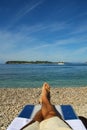 Men relaxing by sea in rocky beach Royalty Free Stock Photo