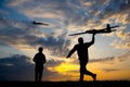 Men with remote controlled airplanes at sunset