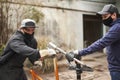 Men removing the paint of an orange bicycle frame during a bike renovation work Royalty Free Stock Photo