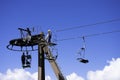 Men repairing a cable chair up on the pylon, high in the sky