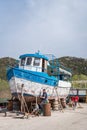 Men repairing and painting old large boat