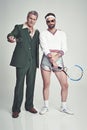 Men, retro and fashion with confidence in studio on white background and smart look with suit and tennis racket. Vintage Royalty Free Stock Photo