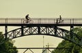 Men riding bicycles across a bridge towards each other in Copenhagen, Denmark Royalty Free Stock Photo