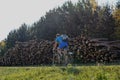 Men riding on a bike on a rural autumn road and cut trees background in the Minsk Belarus