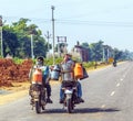 Men riding motorbike with cans