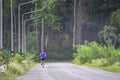 The men are running on the road Background light poles and trees at Kaeng Krachan dam in phetchaburi , Thailand. June 9, 2019