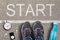 Men Running shoes and equipment on asphalt whit start inscription. Running training on hard surfaces. Runner Equipment stopwatch a Royalty Free Stock Photo