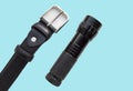 Men`s accessories black leather strap and flashlight isolated on blue background Royalty Free Stock Photo