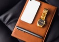Men's accessory, golden watch, pen and mobile phone on the leather diary. Royalty Free Stock Photo