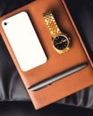 Men's accessory, golden watch, pen and mobile phone on the leather diary. Royalty Free Stock Photo