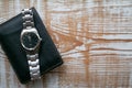 Men`s black leather wallet and metal watch lie on a white wooden texture board. Background with copy space. Concept for Happy Royalty Free Stock Photo