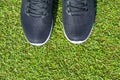 Men`s black sneakers with a white sole on the legs close-up. Royalty Free Stock Photo