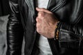 Men`s bracelet made of precious stones and minerals, on a hand in a leather jacket. Close-up Royalty Free Stock Photo