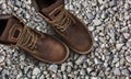 Men`s brown boots on stone gravel background Royalty Free Stock Photo