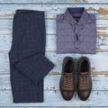 Men`s casual outfits for men clothing set with shoes, trousers, shirt on wooden background, Top view Royalty Free Stock Photo