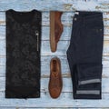 Men`s casual outfits for man clothing set with brown shoes, trousers, shirt isolated on a wood background, Top view Royalty Free Stock Photo