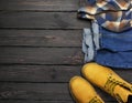 Men`s casual wear, yellow work boots from natural nubuck leather, blue jeans, checkered shirt and brown belt on dark wooden Royalty Free Stock Photo